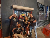 a group of people posing in front of a restaurant
