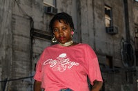 a woman wearing a pink t - shirt and jeans